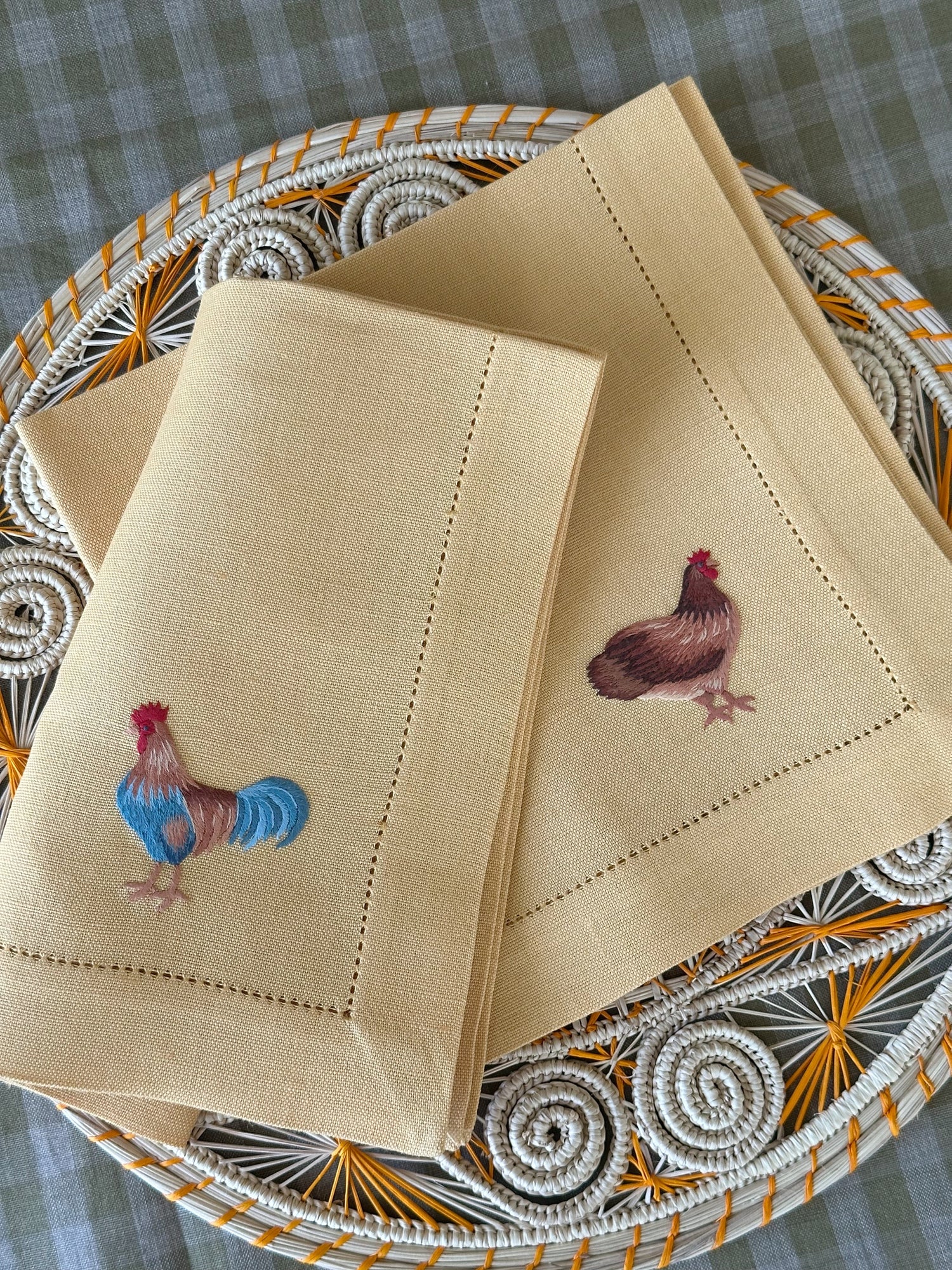 Bilde av fire linservietter med håndbroderier av grønnsaker.